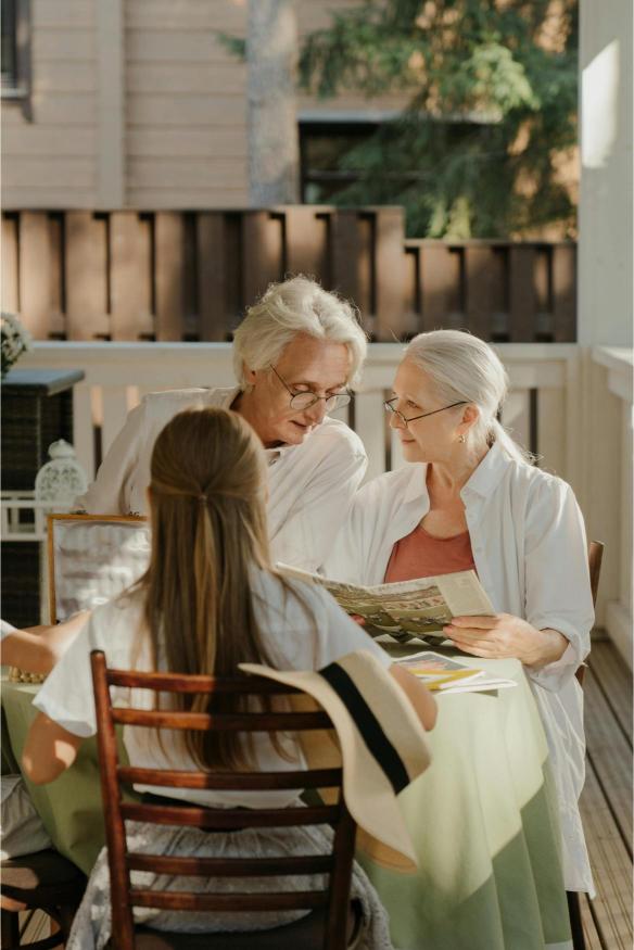 Two seniors and a little girl seated.